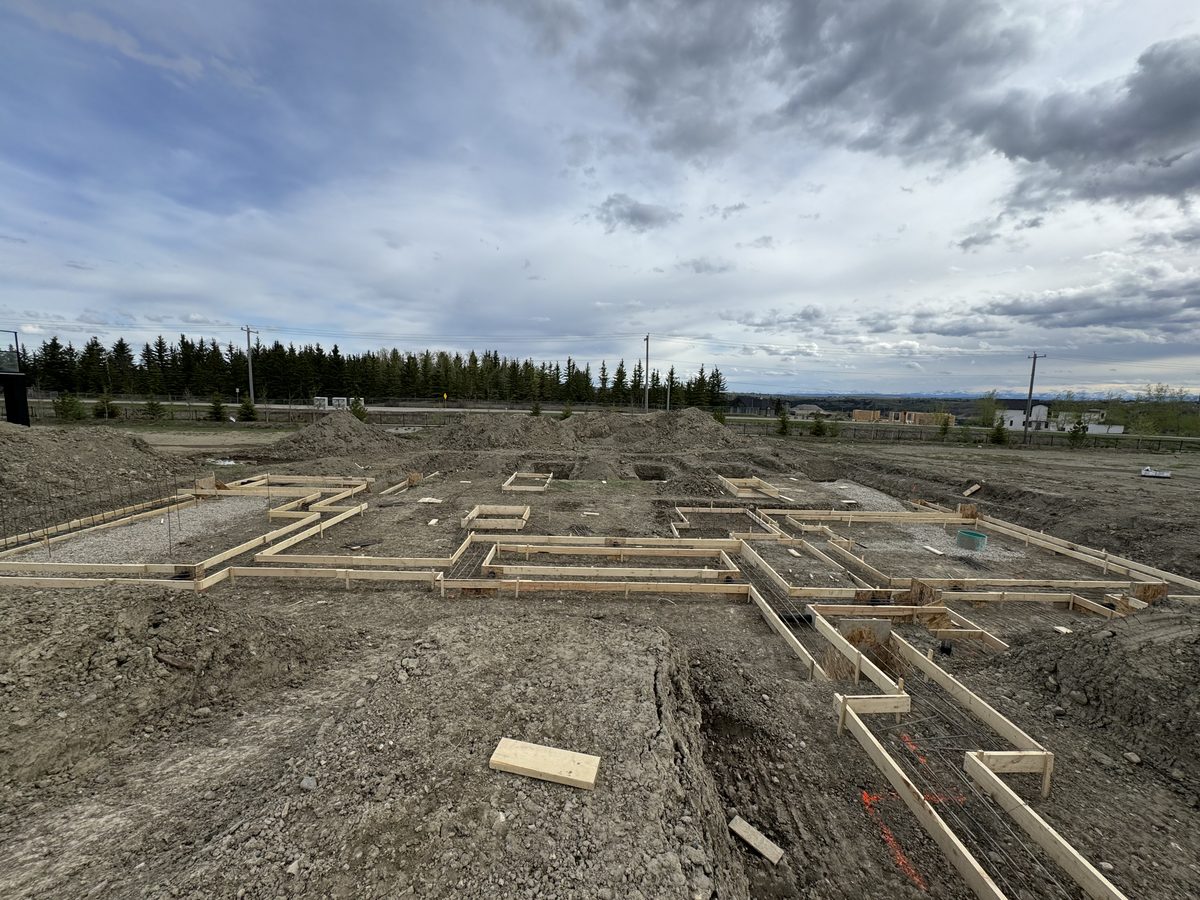 Continuous footing forms laid out with rebar across a single-family excavation